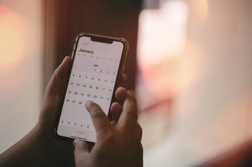 Concept for time management and financial planning reminder 2026. man using smartphone working with year 2026 calendar, business planning marketing and investment