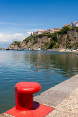 The harbour of Agropoli, Campania, Italy, with a red-painted bollard on the quayside in the foreground