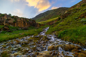 Serene stream flowing through rocky mountainous region in Kyrgyzstan