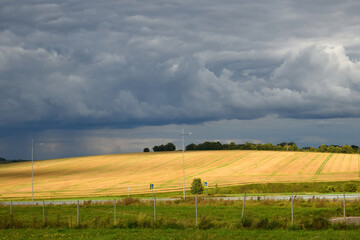 Landscape with a stormy sky, a field and a road
