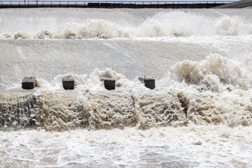 Turbulent water flowing over concrete blocks at dam