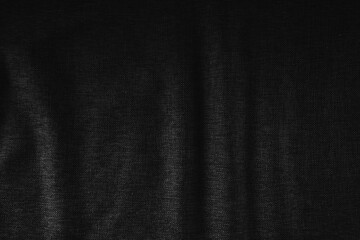 Dark black fabric texture background with soft folds and shadows, minimalist backdrop for design, presentation, advertising, and modern graphic projects.