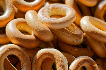 Sunlit pile of bagels and sushki with gentle poppy detail.