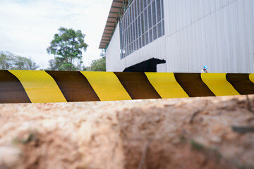 black and yellow warning tape blocking access to a demolition site, symbolizing building eviction,...