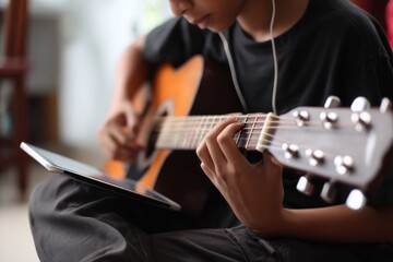 Boy learning guitar with digital tablet