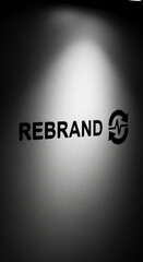 Gray wall with spotlight, showcasing "REBRAND" text and circular renewal symbol, representing business transformation and growth, ideal for marketing or corporate concepts