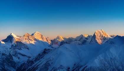 mountain range at sunrise with snowy peaks and clear blue sky