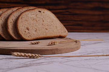 Pane a fette sul tagliere con spighe di grano