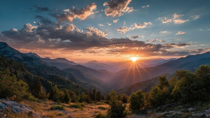 Obraz premium A breathtaking sunset over mountains, casting golden rays across valleys and illuminating the tranquil scenery.
