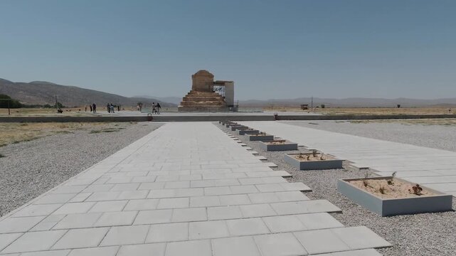 Forward tracking shot approaching the Tomb of Cyrus the Great in Pasargadae, Iran. Iconic Achaemenid monument under clear blue sky, symbol of Persian history and UNESCO World Heritage.