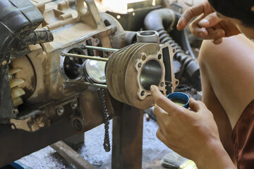 Focused mechanic performs engine repair workshop, careful maintenance ensures automotive