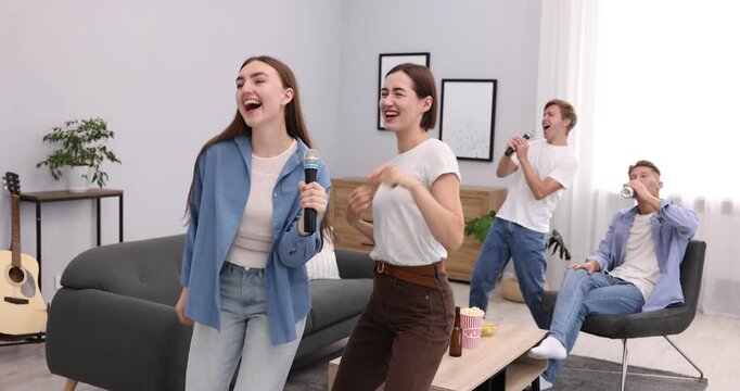 Group of friends singing karaoke at home