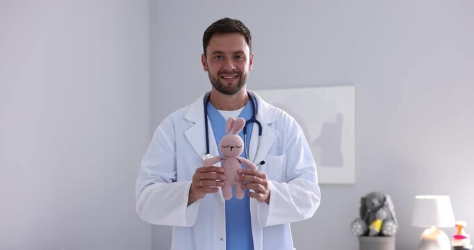 Pediatrician taking toy bunny out of pocket in hospital