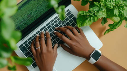Close up of hands typing sql on laptop keyboard in green workspace environment