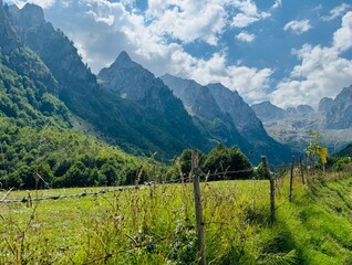 Panoramic view of the Grebaje Valley in Prokletije National Park, Montenegro, surrounded by dramatic rocky peaks and lush green meadows © Марина Гудзь