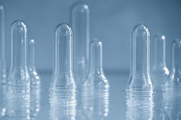Close up scene of group of preform shape of PET bottle products in the light blue scene.