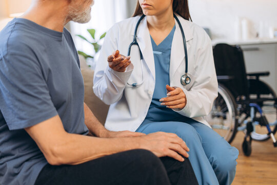 Doctor consulting senior patient during home visit