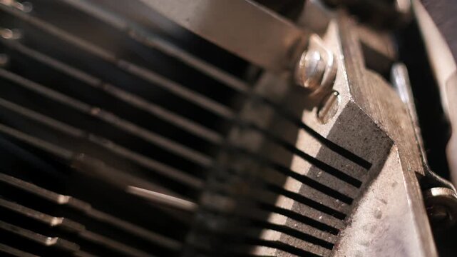 Extreme close up view inside typewriter of type bars in a row. Cinematic shot of hammers typing letters on typewriter.