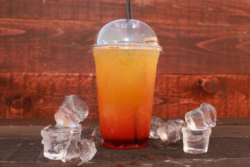 Refreshing citrus cocktail with ice served in glasses on a wooden rustic surface.