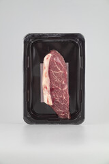 Beef steak in black plastic box isolated on white background with clipping path
