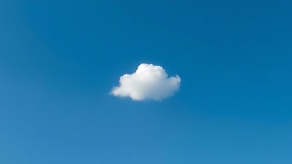 Single fluffy cloud in a vast blue sky, serene atmosphere.