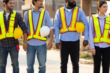 Safety hardhat helmet workwear. Engineering team hand holding white safety helmet or hard hat. Construction worker man in protective suit and reflective vest standing at workplace
