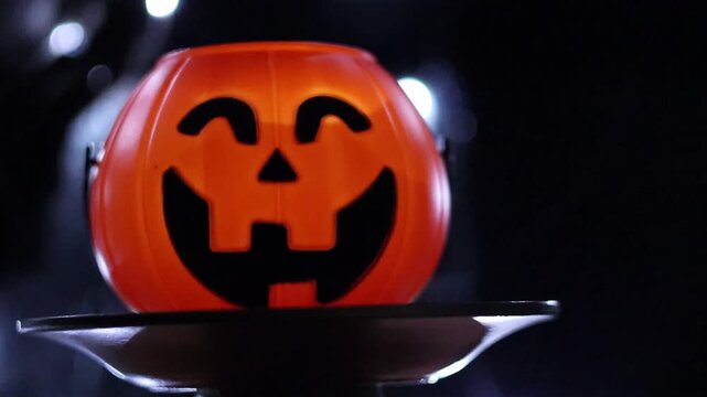 Un primer plano de una calabaza de halloween con un fondo negro con luces desenfocadas. Feliz halloween