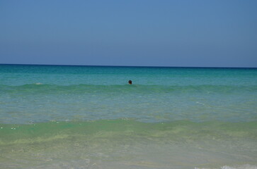 the girl swims toward the ocean