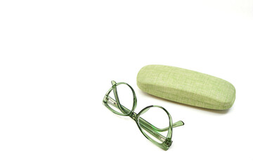 Pair of women's reading glasses with a transparent green cat eye shape frame and a glasses case isolated on a plain white background. Eyesight concept.