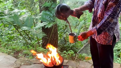 Traditional Indonesian coffee served with hot burning claypot in a cafe in the middle of the pine forest. Food show performances
