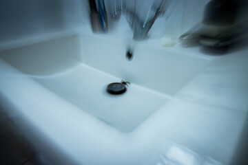 Large spider lurks in sink with motion blur and eerie blue tone – concept of POV shock