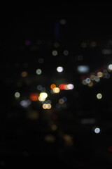 Vertical photo with blurred background of urban lights and vehicle lights