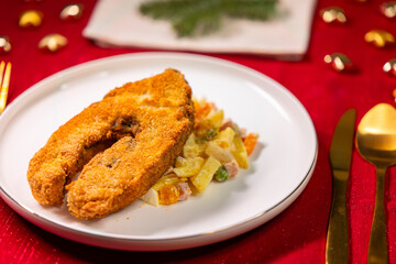 Fried carp with potato salad for festive Christmas dinner
