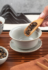 Pouring dried black tea into a gaiwan. Tea ceremony. 