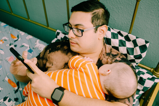 dad on phone holding baby