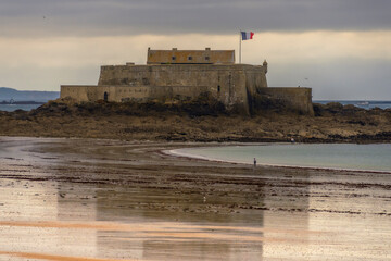 Le fort national de Saint-Malo &agrave; mar&eacute;e basse, drapeau fran&ccedil;ais lev&eacute;.