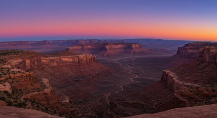 Scenic landscape view of a canyon during sunset with vibrant colorful sky and rocky formations