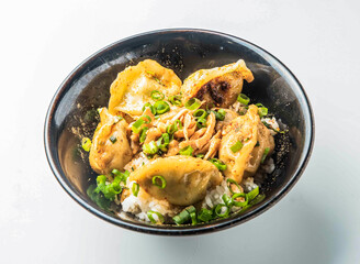 Gyoza Donburi Crispy Japanese Potstickers on Rice with Scallions in a Black Bowl side view of japanese food
