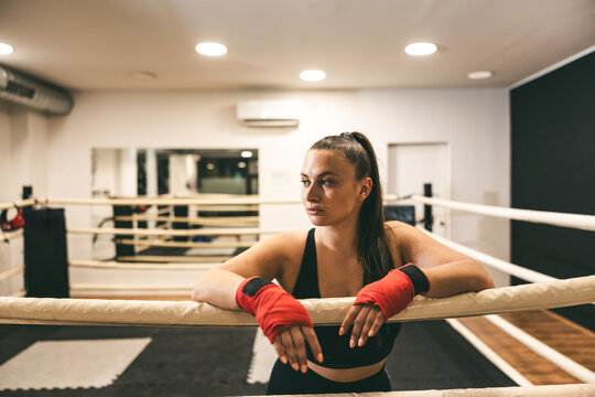 Woman in sportswear resting at boxing gym during training session in modern facility - Powered by Adobe