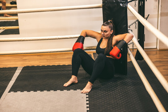 Female boxer resting after intense training session in a gym setting