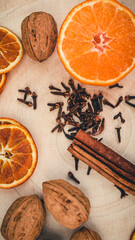 Orangen, Zimtstangen, Nelken und Walnüsse auf einem Tisch