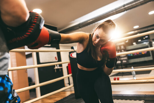 Boxing training session featuring a woman sparring in a modern gym in the afternoon
