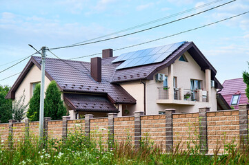 House with solar panels on rooftop for generating electricity through photovoltaic effect. Home with solar power system on roof. Concept of alternative energy, autonomy, power sustainable resources.