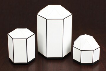 Three white geometric hexagonal prism objects on dark background