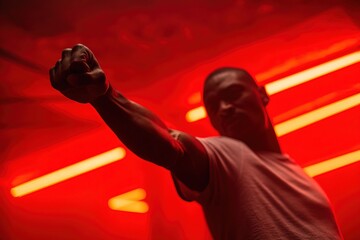 Intense portrait of man training with punch in boxing gym, highlighted by red neon glow, representing discipline, empowerment, athletic performance, suitable for motivational visuals