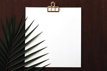White paper on clipboard with palm leaf and gold clip
