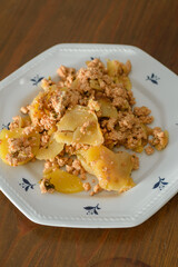 Moussaka, a dish of potatoes and minced meat in a white plate on the table