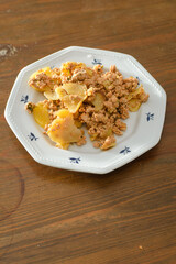 Moussaka, a dish of potatoes and minced meat in a white plate on the table