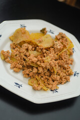 Moussaka, a dish of potatoes and minced meat in a white plate on the table