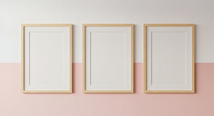 Three empty wooden picture frames arranged on a pastel pink and white wall, minimalist interior decor